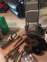 Electrolux floor cleaner with accompanying wrenches, metal tools, buffer brushes, and other parts shown on floor.