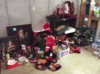 Full view of Christmas decorations including framed pictures, figurines, wreaths, stockings, and brown shelving unit.