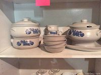 Stoneware casserole dishes, bowls, and soup cups on shelf