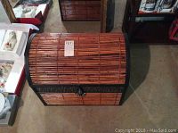 Brown metal trunk with bamboo-style exterior, showing curved top and decorative metal band.