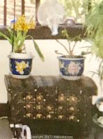 Front view of the antique trunk showing the wrought iron side handles and metal decorative studs.