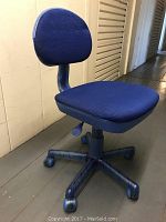 Front view of blue swivel desk chair showing padded seat and backrest with fabric covering, plastic base with caster wheels.