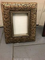 Front view of a decorative gold floral embossed photo frame