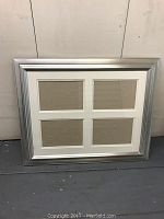 Front view of silver rectangular picture frame with four photo openings and white matting.
