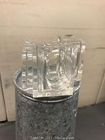 Three clear plastic napkin rings stacked together showing the geometric rectangular design with oval cutouts