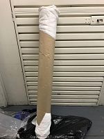 White silk pleated chiffon fabric rolled on a cardboard tube at least 12 yards long.