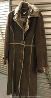 Front view of the brown long fake shearling coat showing wide collar, button closure, and cuff detail.