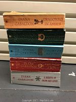 Photo showing spines of five hardback Outlander series books by Diana Gabaldon with titles and author visible