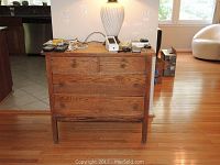 Front view of the vintage oak dresser showing four drawers with wooden knobs and visible oak grain.
