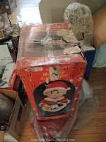 Photo shows boxed 30-light digital animation Christmas tree topper featuring a cartoon Santa figure holding a soccer ball and teddy bear.