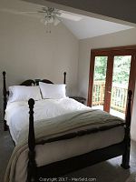 Wide shot of assembled bed showing headboard, footboard, side rails and four turned posts