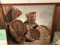 Full front view of framed painting showing composition of woven baskets and background texture