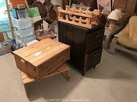 Photo showing file cabinet, wooden shoe shelves stacked, wine rack on top of file cabinet, and hat rack nearby.