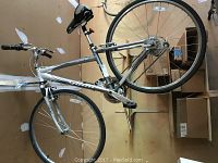 Side view of the silver Giant Cypress DX bicycle showing frame, tires, pedals, handlebars, and saddle.