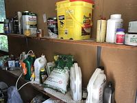 Photo showing shelves stocked with various garden and home maintenance supplies including Scott's fertilizer, Preen weed preventer, Ortho Weed B Gon, paint thinner, spray paint, driveway cleaner and assorted bottles and cans.