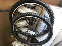 Pair of 26-inch knobby tire wheels stacked, showing tread and rims