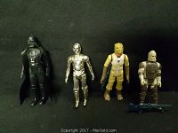 Four Star Wars vintage action figures standing on black fabric: Darth Vader, C-3PO, Bossk, and Dengar.