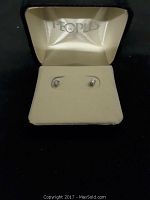 Pair of 14 KT gold diamond stud earrings in a cream jewelry box with 'Peoples' logo.