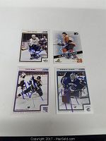 Four signed hockey cards laid out on white background. Players Shea Weber, Claude Giroux, Rick Nash, Roberto Luongo shown wearing team uniforms.