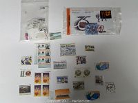 Photo showing a spread of uncirculated stamps on white background including loose and bagged stamps