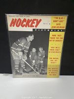 Front cover of the February 1964 Hockey Pictorial Magazine showing Jean Beliveau with two young hockey players on the ice and headline quotes.