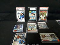 Overview shot of 9 baseball cards displayed in PSA graded and ungraded holders, featuring multiple players including Reggie Jackson, Pete Rose, and Paul Molitor