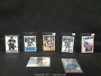 Front view of several hockey cards including Wayne Gretzky and others, displayed upright and flat on black background.