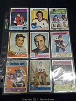 Photo showing a collection of 9 hockey cards in plastic sleeves arrayed in three rows, including famous players like Gilbert Perreault, Bill Reay, and Billy Smith.