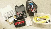 View of the two Husky tool bags, cordless drill and screwdriver, assorted screws, and plastic bins with hardware