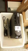 Photo of black Dell desktop computer possibly with LG optical drive, without power cord, sitting inside a white Ikea recycle bin.