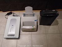 Full lot view showing scanner, laser printer, and shredder arranged on tiled floor.