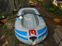 Full view of the Bestway Shark inflatable boat with two paddles attached on sides, showing boat's shape and condition.