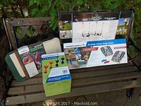 Photo showing all four unopened outdoor game sets placed on a wooden bench outdoors.