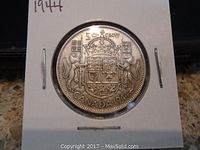 Reverse view of the 1944 Canadian 50 cent coin showing the Canadian coat of arms and denomination.