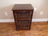 Front view of wicker 3 drawer storage cabinet with wood frame and metal handles, showing all drawers closed.
