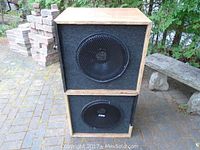 Two stacked Hall speakers with wooden cabinets and black grille, showing wear on cabinet edges.