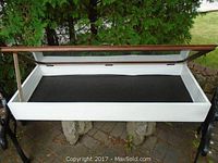 Display case with the glass top open showing the interior, wooden frame, and white painted sides.