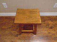 Top view of pine wood stool showing rectangular seat and wood grain.