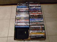 Top view of about 60 DVDs arranged in 3 stacks with titles visible on spines.