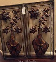 Full view of the two framed metal floral wall decor pieces side by side.