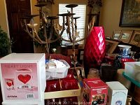 Wide view of candle holders, red vase, boxed candle, and other decorative items on table