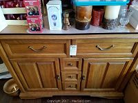 Full front view of Keller oak buffet table with drawers, cabinets, and custom pads visible on top.