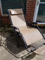 Weber charcoal grill with lid and cooking grate shown outside on patio, black finish, some wear visible.