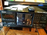 Front view of Pioneer PD-F1009 with mirrored carousel and remote on top