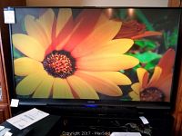 Front view of TV displaying image on stand