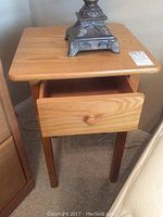 Wood end table with drawer showing intact drawer open and wood knob.