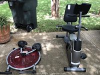 Diamondback recumbent bike and ab cruncher placed outdoors on concrete surface with grass background.