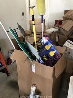 Full view of assembled home and garden tools including duster, bulb changer kit, sweeper, shovel, and rake in a box.