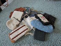 Overview photo showing assortment of vintage beaded purses and eyeglass holders in various colors and styles on carpeted floor.