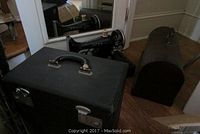 Two Singer sewing machines side by side in carrying cases